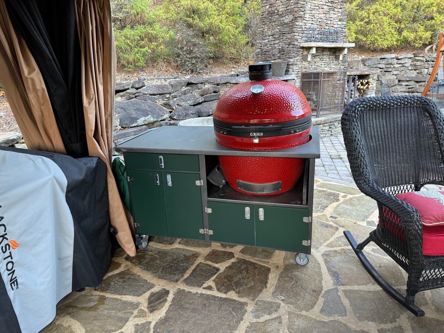 Red ceramic grill on outdoor patio setup.